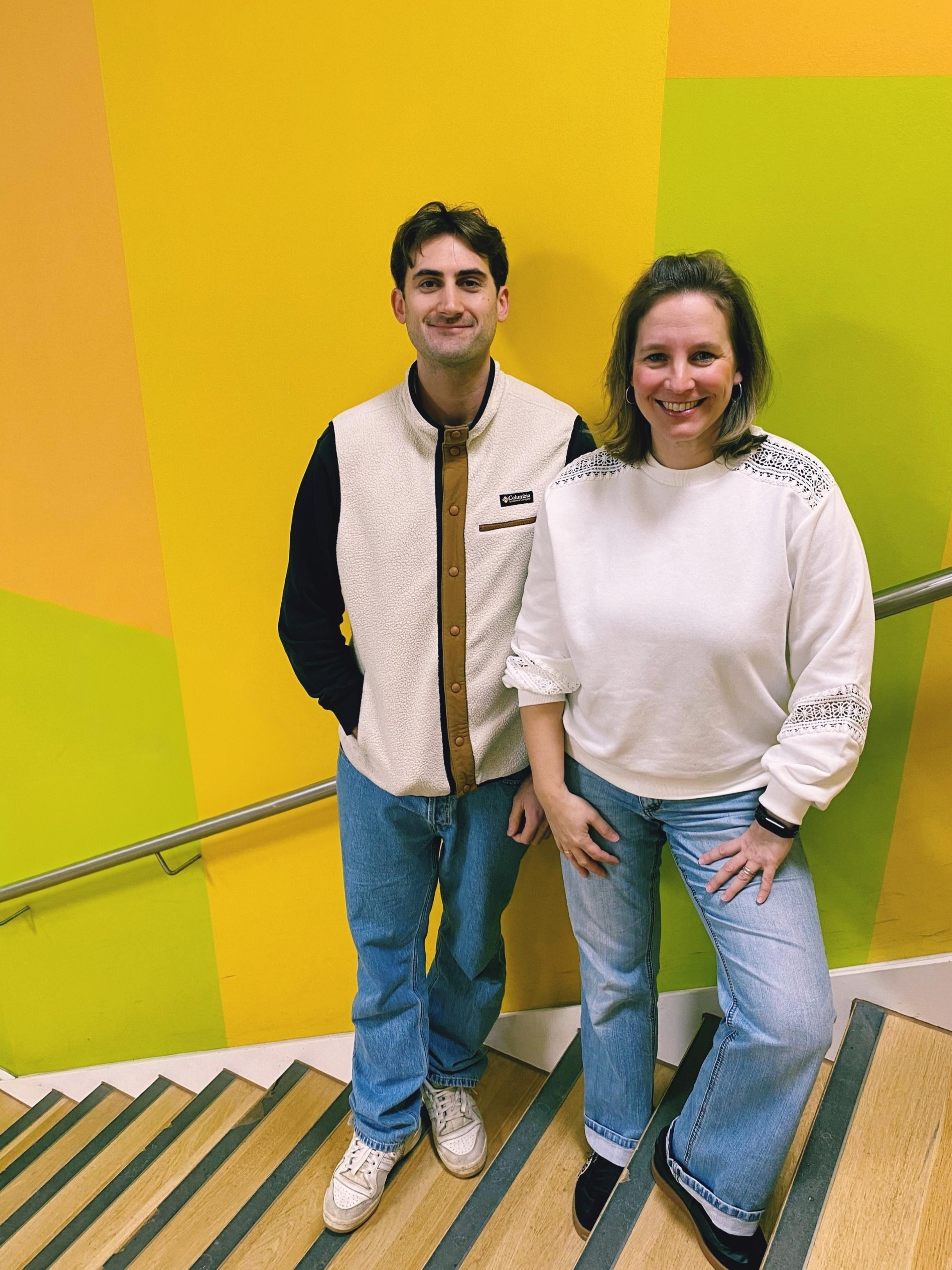 Mann und Frau stehen auf Treppe und schauen in die Kamera